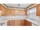 Charming kitchen with wood cabinets, light countertops, tile backsplash, and decorative wallpaper at 6349 5Th Street E Cir, Bradenton, FL 34203