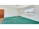 Sunlit living room with a large window, neutral walls, carpeted flooring, and a door leading to the outside at 6349 5Th Street E Cir, Bradenton, FL 34203
