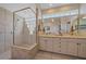 Bright bathroom featuring a dual sink vanity, glass block window, and walk-in glass shower at 6617 Nautical Dr, Lakewood Ranch, FL 34202
