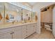 Bathroom featuring a dual sink vanity, large mirror, and a convenient linen closet at 6617 Nautical Dr, Lakewood Ranch, FL 34202