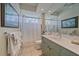 Bright bathroom featuring tiled floors, a shower with glass block window, and a vanity with ample storage at 6617 Nautical Dr, Lakewood Ranch, FL 34202