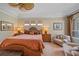 Warm bedroom featuring a ceiling fan, neutral walls, seating area, and wood furnishings at 6617 Nautical Dr, Lakewood Ranch, FL 34202