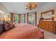 Comfortable bedroom with ceiling fan and bay window overlooking a patio and a landscaped yard at 6617 Nautical Dr, Lakewood Ranch, FL 34202