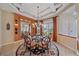 Elegant dining room featuring a coffered ceiling, modern chandelier, and a round glass table at 6617 Nautical Dr, Lakewood Ranch, FL 34202