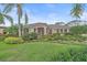 Inviting single-story home featuring a manicured lawn, lush tropical landscaping and a tile roof at 6617 Nautical Dr, Lakewood Ranch, FL 34202