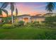 Inviting single-story home featuring a manicured lawn, lush tropical landscaping and a tile roof at sunset at 6617 Nautical Dr, Lakewood Ranch, FL 34202