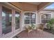 Charming front porch with pink door, wicker chairs, and a view of lush landscaping at 6617 Nautical Dr, Lakewood Ranch, FL 34202