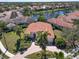 Aerial view of a home featuring a red tile roof, verdant landscaping, and a circular driveway at 7141 Whitemarsh Cir, Lakewood Ranch, FL 34202