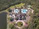 Aerial view of a community clubhouse with multiple pools, ample parking, and well-maintained landscaping at 7141 Whitemarsh Cir, Lakewood Ranch, FL 34202