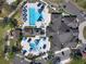 Overhead view of a community pool and clubhouse area with multiple pools, cabanas, and lounge chairs at 7141 Whitemarsh Cir, Lakewood Ranch, FL 34202