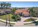 Beautiful home with a barrel tile roof and tropical landscaping including mature palm trees and a brick paver driveway at 7141 Whitemarsh Cir, Lakewood Ranch, FL 34202