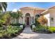 Inviting front entrance featuring an arched doorway, elegant columns, and meticulously maintained landscaping at 7141 Whitemarsh Cir, Lakewood Ranch, FL 34202
