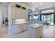 Well-lit kitchen showcases white cabinetry, a central island, and views into the adjacent dining and living areas at 7141 Whitemarsh Cir, Lakewood Ranch, FL 34202