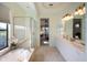 Bright main bathroom featuring a walk-in shower, soaking tub, dual sinks, and views into the main bedroom at 7141 Whitemarsh Cir, Lakewood Ranch, FL 34202