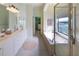 Spacious main bathroom featuring dual vanities, a soaking tub, a glass-enclosed shower, and a walk-in closet at 7141 Whitemarsh Cir, Lakewood Ranch, FL 34202