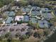 Aerial view of multiple community tennis courts and parking, surrounded by trees and a tranquil pond at 7141 Whitemarsh Cir, Lakewood Ranch, FL 34202