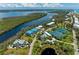 Scenic aerial view of waterfront property with lush greenery, tennis courts, and community pool at 7490 Palm Island Dr # 2324, Placida, FL 33946