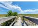Scenic wooden walkway leading to a beautiful beach with white sand and clear blue water at 7490 Palm Island Dr # 2324, Placida, FL 33946