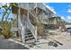 Exterior view of a multi-story beach condo featuring stairs and white railing on a sunny day at 7490 Palm Island Dr # 2324, Placida, FL 33946