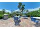 Outdoor grilling area with palm trees, tables, and chairs for dining at 7490 Palm Island Dr # 2324, Placida, FL 33946