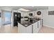 Bright kitchen featuring white cabinets, black appliances, granite counters, and sleek, modern hardware at 7490 Palm Island Dr # 2324, Placida, FL 33946