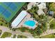 Breathtaking aerial view of a luxury pool and spa surrounded by tropical landscape and tennis courts at 7490 Palm Island Dr # 2324, Placida, FL 33946