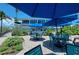 Outdoor seating at Coconuts Island Rentals restaurant with vibrant blue umbrellas and lush landscaping at 7490 Palm Island Dr # 2324, Placida, FL 33946