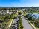 Aerial view of a gated community entrance with palm trees, well-manicured landscaping, and a scenic pond at 8619 Firefly Pl, Parrish, FL 34219