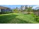 Large backyard with lush lawn, lounge chair, black fence, shade sail and screened pool at 8619 Firefly Pl, Parrish, FL 34219