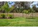 A picturesque view of a black metal fence lined with small palm trees and lush greenery at 8619 Firefly Pl, Parrish, FL 34219