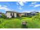 Lush green backyard with a black fence, patio, a grill, and lounge chair, offering privacy at 8619 Firefly Pl, Parrish, FL 34219