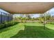 Expansive backyard with lush green lawn, bordered by a black fence and shade sail at 8619 Firefly Pl, Parrish, FL 34219