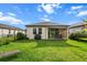 Lush green backyard featuring a black fence, patio, grill, and relaxing lounge chairs at 8619 Firefly Pl, Parrish, FL 34219
