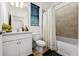 Bright bathroom featuring a shower-tub combo with earth-toned tiles and stylish vanity with framed mirror at 8619 Firefly Pl, Parrish, FL 34219