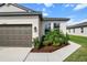 Close-up of home's elevation and landscaping with green shrubs near windows and mulched flower beds at 8619 Firefly Pl, Parrish, FL 34219