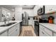 Modern kitchen with stainless steel appliances, white cabinetry, and quartz countertops at 8619 Firefly Pl, Parrish, FL 34219