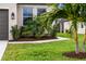 Lush landscaping featuring a palm tree, mature shrubs, and a well-maintained lawn surrounding the property at 8619 Firefly Pl, Parrish, FL 34219