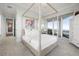 Light and bright bedroom boasting large windows, four-poster bed, and access to a balcony with a view at 3935 N Shell Rd, Sarasota, FL 34242