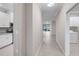 Bright hallway featuring tile flooring and access to the laundry area and a glimpse into the living area at 12720 Sorrento Way # 102, Bradenton, FL 34211