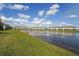 Community backyard view facing toward a picturesque pond and surrounding lawn at 15147 Sunny Day Dr, Bradenton, FL 34211