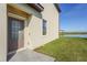 Rear exterior of home by pond featuring paved patio and a convenient door with large window at 15147 Sunny Day Dr, Bradenton, FL 34211