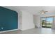 Bright living room with gray tile flooring, accent wall, and sliding glass doors that open to a lanai at 15147 Sunny Day Dr, Bradenton, FL 34211