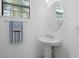 Bright powder room features pedestal sink, mirror, and towel bar at 15147 Sunny Day Dr, Bradenton, FL 34211