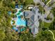Aerial image of the community pool, with a splash pad, lounge chairs, and lush greenery at 1604 Still River Dr, Venice, FL 34293