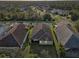 An aerial view shows the home's roof, landscaping, and proximity to other houses in the neighborhood at 1604 Still River Dr, Venice, FL 34293