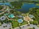 Aerial view of the community amenities, including a pool, playground, and recreational areas by the lake at 1604 Still River Dr, Venice, FL 34293