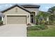 Charming home exterior featuring a stone facade, two-car garage, and well-maintained landscaping at 1604 Still River Dr, Venice, FL 34293