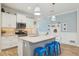 Bright kitchen features a large island with seating, stainless steel appliances and custom backsplash at 1604 Still River Dr, Venice, FL 34293