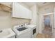 Clean laundry room with modern washer and dryer, a sink, and ample cabinet space at 1604 Still River Dr, Venice, FL 34293