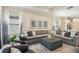 Spacious living room with a large sectional sofa, tray ceiling, and ample natural light at 1604 Still River Dr, Venice, FL 34293